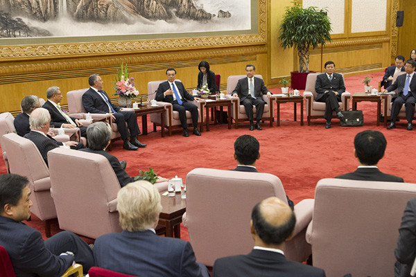 Premier Li Keqiang meets heads of delegations to attend the 21st APEC Finance Ministers Meeting at the Great Hall of People in Beijing on Oct 21, 2014. [Photo/Xinhua]