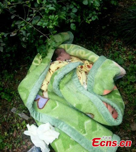 A baby is found dead in the nature strip in Yibin city, Southwest China's Sichuan province on Wednesday, Nov 19, 2014. Local police are investigating the death of the baby who was abandoned on the road verge. (Photo: China News Service/Li Jingyi)
