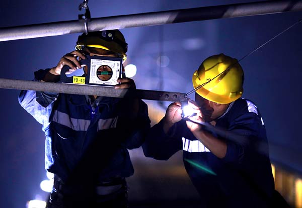 Workers check the electric line on Guangzhou high-speed railway track in East China's Guangdong province, Oct 11, 2011. [Photo by Chen Qiaoling/provided to chinadaily.com.cn]