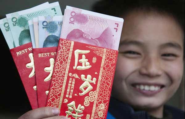 A boy shows the red envelopes he received during the Spring Festival. Photo by Lyu Jianshe / for China Daily