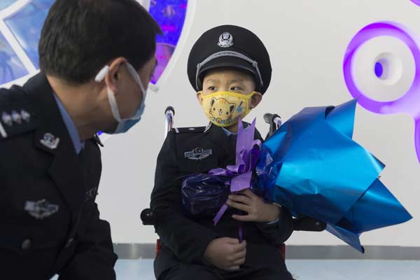 Liu Zixi talks with a police officer during the ceremony, March 16, 2015. (Photo/China Daily)