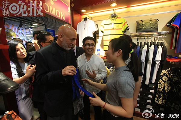 Hamid Karzai picks up a blue tie in a tailor shop on the second floor of the Silk Street (Xiushui) Market in downtown Beijing on May 26, 2015. (Photo/fawan.com)