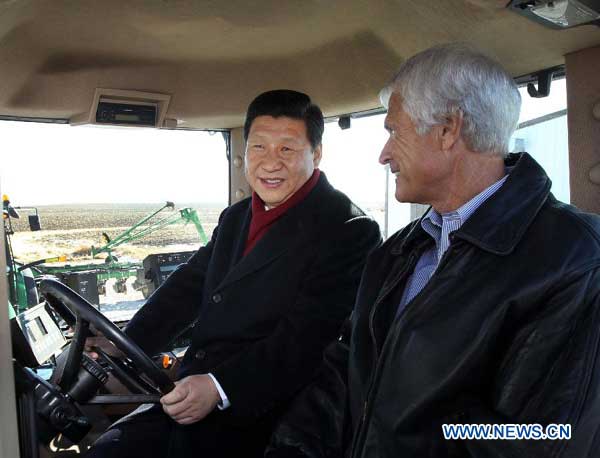 Chinese Vice-president Xi Jinping (L) talks with farmer Rick Kimberley as they sit in the cab of a tractor in Des Moines, Iowa, Feb. 16, 2012. (Photo/Xinhua)