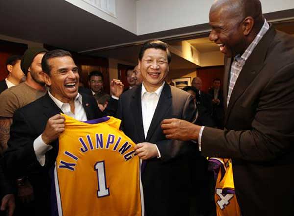 Then Chinese vice-president Xi Jinping, center, receives a Los Angeles Lakers jersey signed by Kobe Bryant in front of David Beckham, back, and former Lakers star Magic Johnson when Xi was watching a National Basketball Association game in Los Angeles during his visit to the United States on Feb. 17, 2012. (Photo/Xinhua)