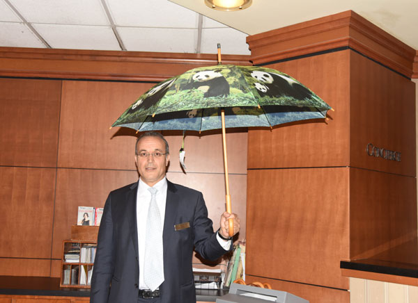 A staff member at the Washington Wardman Hotel displays an umbrella with giant panda designed on it on Tuesday as President Xi Jinping begins his state visit to the United States. Photo provided to China Daily.