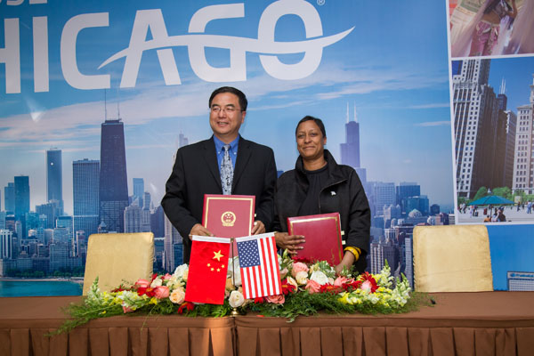 Zhao Haisheng (left), vice-general director of the bureau for external culture relations of the Chinese Ministry of Culture, and Melissa Cherry, vice-president for cultural tourism and neighborhoods at Choose Chicago, hold a Memorandum of Understanding on cultural cooperation that they signed earlier in May, 2015 in China. （Photo provided to China Daily）