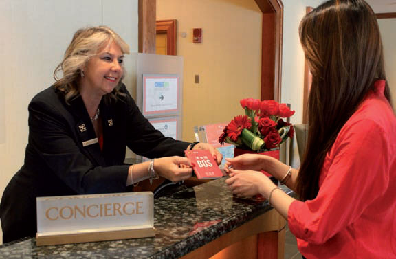 Betty Salemme, chief concierge of The Seaport Hotel, hands a customer a new Chinese-language map of Boston put together by Attract China. Boston is seeing an increasing number of Chinese travelers. (Photo provided to China Daily)
