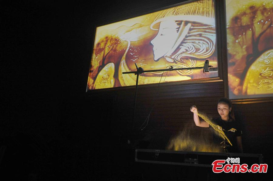 Girl paints dream with sand 