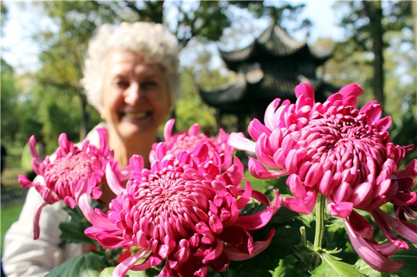 An elderly woman enjoys the chrysanthemum flowers at the Humble Administrator's Garden in Suzhou on the Double Ninth Festival, which falls on Oct 9, 2016. (Photo/Asianewsphoto)