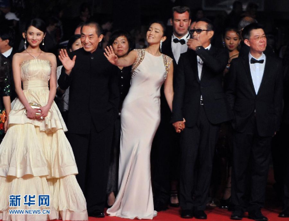 Film director Zhang Yimou(L2) and actress Gong Li (L3) wave to the public at Cannes Film Festival in 2014. (Photo/Xinhua) 