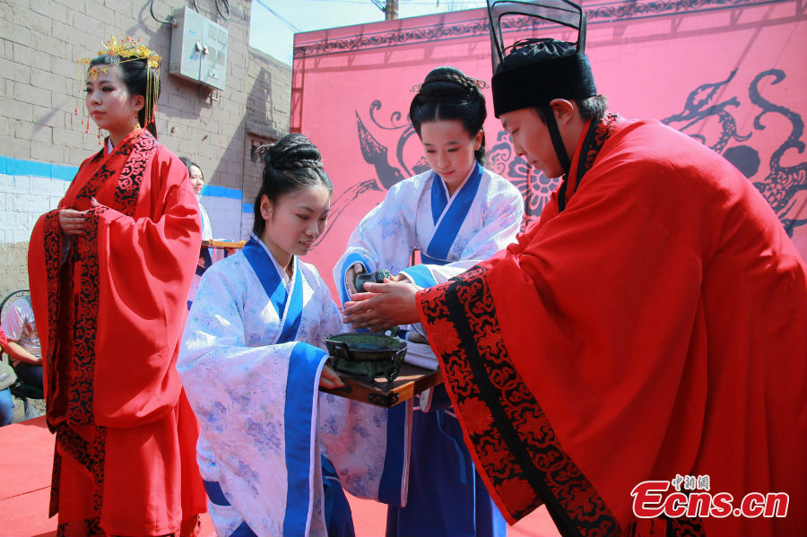 
A couple in costumes of the Han Dynasty (202 BC-220 AD) are seen in their wedding ceremony held in Xi\'an, Shaanxi Province, March 25, 2013. [Photo: Guo Zeyuan]