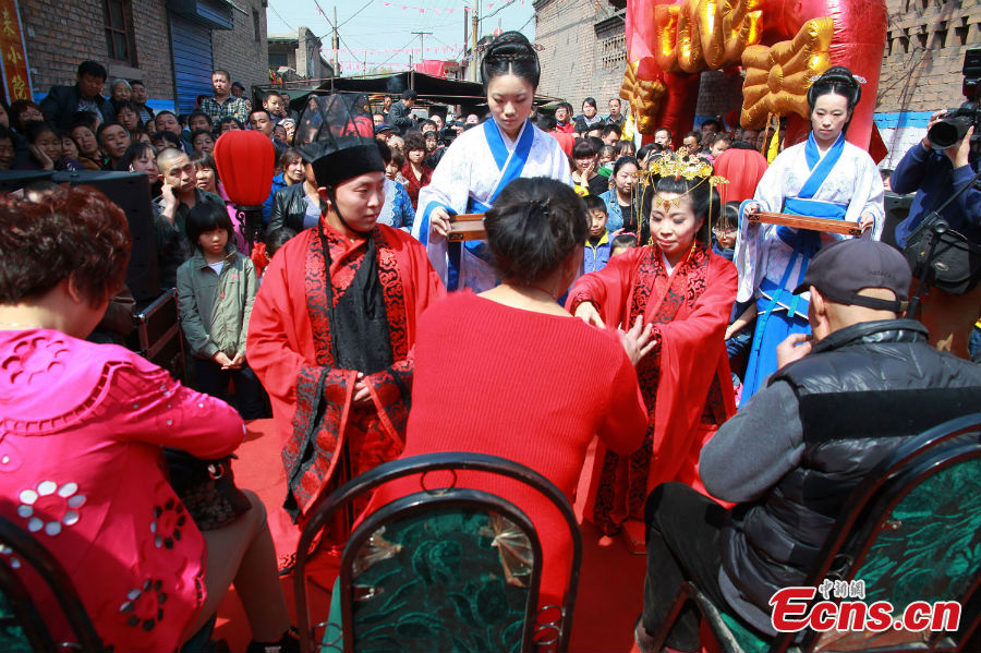 
A couple in costumes of the Han Dynasty (202 BC-220 AD) are seen in their wedding ceremony held in Xi\'an, Shaanxi Province, March 25, 2013. [Photo: Guo Zeyuan]
