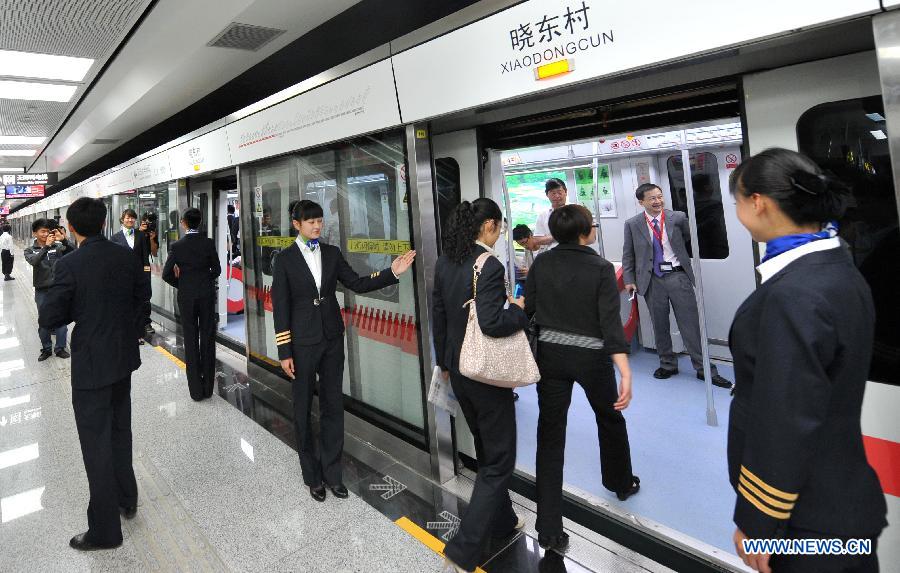 Citizens board a train at a station of the newly-opened subway line in Kunming, capital of southwest China\'s Yunnan Province, May 20, 2013. The southern part of the first phase of Kunming subway line 1 and line 2 opened for trial operation on Monday. It\'s China\'s first plateau subway. (Xinhua/Lin Yiguang)