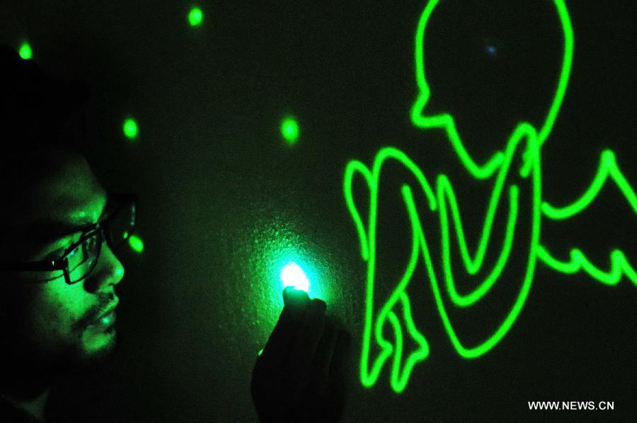 
Liu Hongxin composes an angel-themed light painting using a flashlight in his  studio in Fuzhou, capital of southeast China\'s Fujian Province, Jan. 20, 2014.  An electrical engineering major, Liu Hongxin fell in love with the art of light  painting in summer 2010. Liu was still a university student back then and, with  his own effort, learned light painting from video clips featuring foreign  artists\' performances. After more than a year\'s practice, the self-taught light  painter made his debut in October 2011, and has held nearly 100 performances  eversince. In December 2013, Lin won acclaims for his outstanding performance in  the hit talent show \