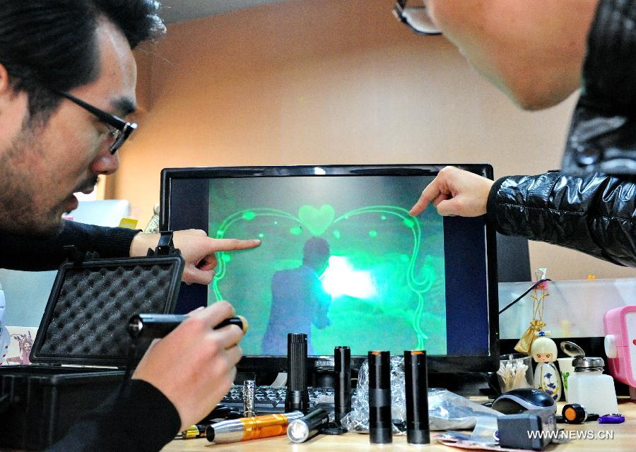 
Liu Hongxin (L) discusses light painting with a colleague in his studio in  Fuzhou, capital of southeast China\'s Fujian Province, Jan. 21, 2014. An  electrical engineering major, Liu Hongxin fell in love with the art of light  painting in summer 2010. Liu was still a university student back then and, with  his own effort, learned light painting from video clips featuring foreign  artists\' performances. After more than a year\'s practice, the self-taught light  painter made his debut in October 2011, and has held nearly 100 performances  eversince. In December 2013, Lin won acclaims for his outstanding performance in  the hit talent show \