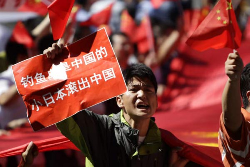 A protester, taking part in a demonstration outside the Japanese embassy in Beijing on Thursday, displays a sign stating that The Diaoyu Islands belong to China, Japan get out of China. Jason Lee / Reuters