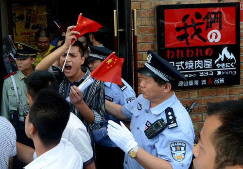 Anti-Japanese demonstrators shout slogans as they leave a Japanese restaurant in Beijing on Thursday after protesting over Tokyo's decision to buy the Diaoyu Islands in the East China Sea. Mark Ralston / Agence France-Presse