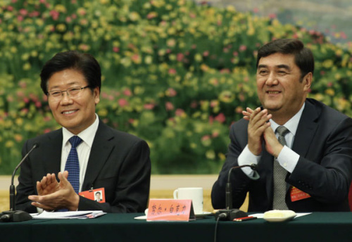 Nur Bekri, right, chairman of the Xinjiang Uygur autonomous region, and Zhang CHunxian, Party chief of Xinjiang, applaud during a session of the ongoing 18th Party Congress in Beijing on Friday. [Photo by Xu Jingxing/China Daily]