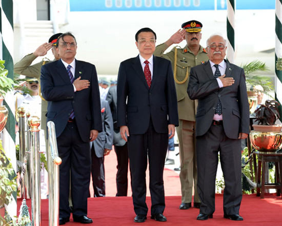 The premier is welcomed at the airport by Pakistan's President Asif Ali Zardari (left) and interim prime minister Mir Hazar Khan Khoso (right) upon his arrival in Islamabad, Pakistan, on Wednesday. Ma Zhancheng / Xinhua