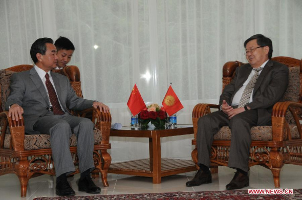 Chinese Foreign Minister Wang Yi (L) meets with Kyrgyzstan's Prime Minister Zhantoro Satybaldiyev in Cholpon-Ata, Kyrgyzstan, July 14, 2013. Prime Minister Zhantoro Satybaldiyev pledged Sunday to deepen cooperation with China when meeting with visiting Chinese Foreign Minister Wang Yi. (Xinhua/Guan Jianwu)