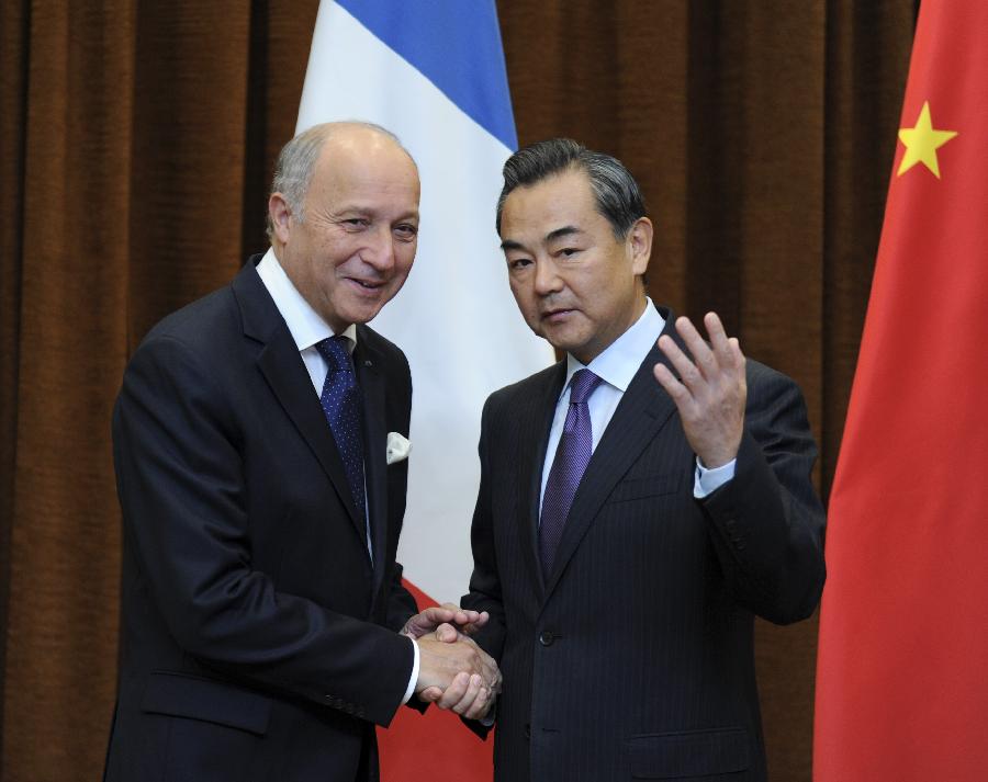 Chinese Foreign Minister Wang Yi (R) shakes hands with his French counterpart Laurent Fabius during their talks in Beijing, capital of China, Sept. 15, 2013. (Xinhua/Zhang Duo)
