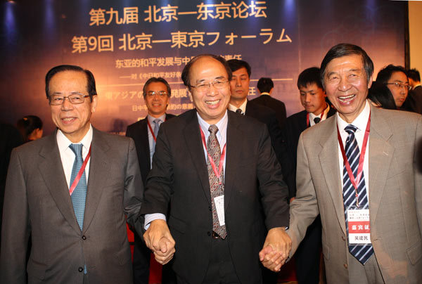 From left: Former Japanese prime minister Yasuo Fukuda, Zhao Qizheng, former chairman of the Foreign Affairs Committee and former minister of the State Council Information Office, and Wu Jianmin, vice-chairman of the China Institute for Innovation and Development Strategy and former Chinese ambassador to France, join hands after the Beijing-Tokyo Forum on Sunday in Beijing. Zou Hong / China Daily