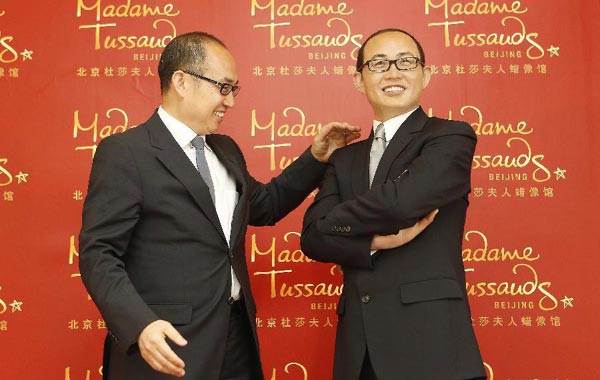 Real estate tycoon Pan Shiyi poses with the waxwork model of himself during an unveiling ceremony at the Madame Tussauds Wax Museum in Beijing, China, April 16, 2014. [Photo/Xinhua]