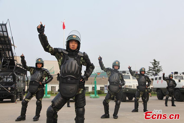 Police officers perform the square dance Little Apple in Jilin city of northeast China's Jilin province on July 29, 2014. Chinese pop duo Chopsticks Brothers' new song Little Apple has become an internet sensation after being remixed and re-edited by fans across China since it was released in May. [Photo/Cang Yan]