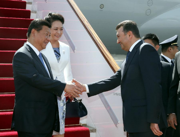 Chinese President Xi Jinping (L) and his wife Peng Liyuan (2nd L) are welcomed by Tajik Prime Minister Qohir Rasulzoda (front R) upon their arrival in Dushanbe, capital of Tajikistan, Sept. 11, 2014. Xi Jinping would attend the 14th summit of the Shanghai Cooperation Organization (SCO) and pay a state visit to Tajikistan. (Xinhua/Ju Peng)
