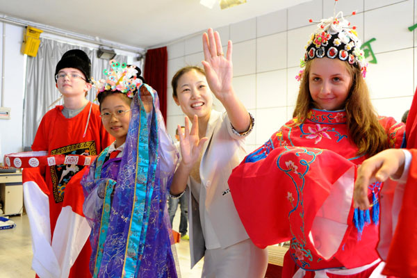 A teacher (center) instructs Chinese and Russian students in traditional Chinese opera at Heihe Experimental Elementary School in Heilongjiang province on May 19. Sixty Russian students from Blagoveshchensk visited the school as part of the Friendship Bridge youth cultural exchange program between China and Russia. [Photo/Xinhua]