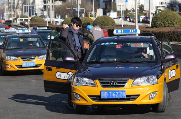 Taxis near Beijing Railway Station take passengers on Friday. Last Thursday, the Ministry of Transport has prohibited private cars from taking passengers for profit in response to strikes by taxi drivers in some cities. Wang Zhuangfei/CHINA DAILY  