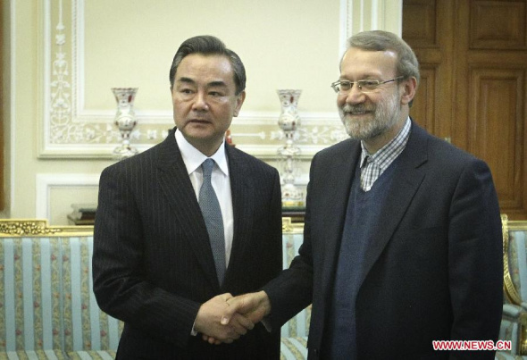 Chinese Foreign Minister Wang Yi (L) shakes hands with Iranian Parliament speaker Ali Larijani in Tehran, capital of Iran, on Feb. 16, 2015. (Xinhua/Ahmad Halabisaz) 