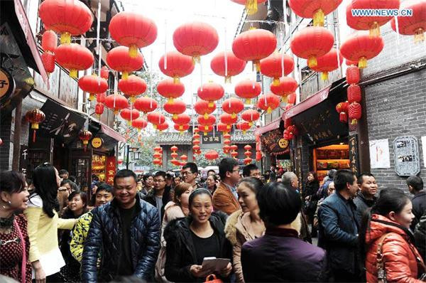 Tourists are seen on a street in Ciqikou Town, southwest China's Chongqing Municipality, Feb 20, 2015. According to local department, the town has received more than 90,000 tourists during the first two days of Chinese Lunar New Year holiday. Some regulations have been carried out to control the number of tourists. (Photo/Xinhua)
