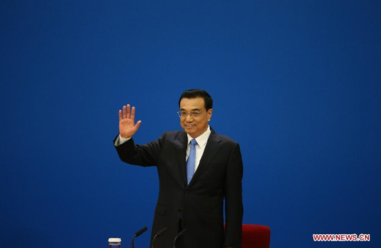Chinese Premier Li Keqiang greets journalists upon arriving at his press conference after the closing meeting of the third session of China's 12th National People's Congress (NPC) at the Great Hall of the People in Beijing, capital of China, March 15, 2015. (Xinhua/Chen Jianli)