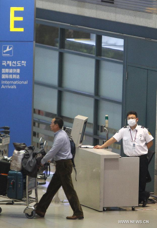 A member of working staff wearing a mask is seen at Incheon International Airport in Incheon, South Korea, on May 30, 2015. Another new case of Middle East Respiratory Syndrome (MERS) was confirmed on Saturday, the South Korea's health ministry said. The number of MERS patients confirmed in South Korea increased to 12. (Xinhua/Yao Qilin)