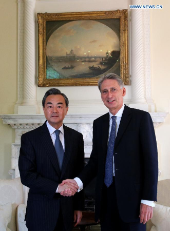 Chinese Foreign Minister Wang Yi (L) shakes hands with British Foreign Secretary Philip Hammond in prior of their meeting in London, Britain, June 9, 2015. (Xinhua/Han Yan)