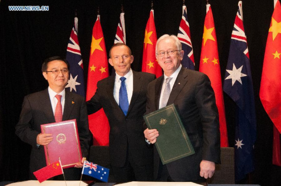 China's Commerce Minister Gao Hucheng (L) and Australia's Trade Minister Andrew Robb (R) pose for photos with Australian Prime Minister Tony Abbott after signing the China-Australia Free Trade Agreement at the National Gallery in Canberra June 17, 2015. (Photo: Xinhua/Justin Qian)