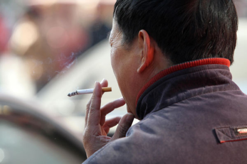 A man takes a cigarette break in a public place in Nantong, Jiangsu province, on Nov 30, 2013. (Provided to China Daily)