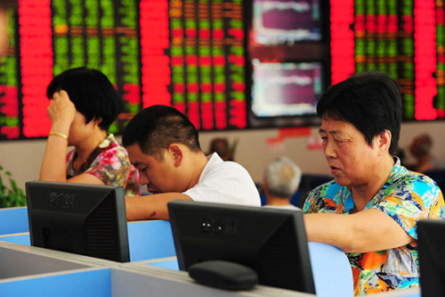 Investors at a brokerage in Fuyang, Anhui province. Between mid June and early July, the Shanghai Composite Index tumbled nearly 30 percent from its peak, prompting the government to take a series of rescue measures to stem the slide. (Photo/China Daily)