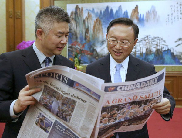 State Councilor Yang Jiechi (right) reads a copy of China Daily as Sun Shangwu, China Daily's Deputy Editor-in-Chief, describes the editing process of the newspaper after an interview in Beijing.(Photo by Xu Jingxing/ China Daily)