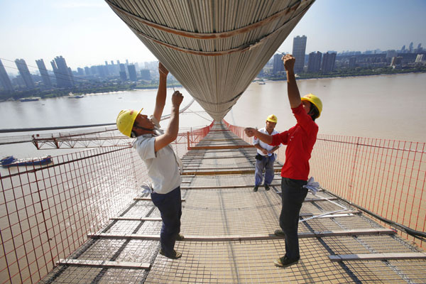 A bridge over the Yangtze River under construction in Wuhan, Hubei province. It will be the eighth Yangtze River bridge in the city and is evidence of ongoing infrastructure development. The country is making preparations for drafting the next five-year economic development plan (2016-20), which may put emphasis on boosting domestic demand. (Photo/China Daily)