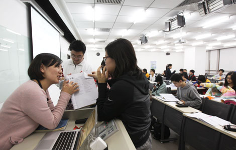 A teacher answers questions from students preparing to take the SSAT, the Secondary School Admission Test, in Hong Kong. (Photo/China Daily)