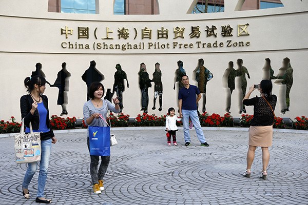Shanghai residents take pictures at the China (Shanghai) Pilot Free Trade Zone. (Photo/China Daily)