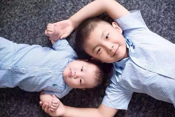 A boy with his younger brother. (Photo provided to chinadaily.com.cn)