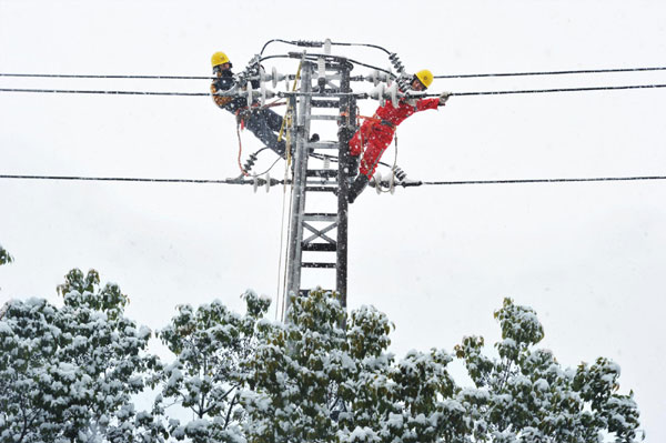 Workers repair electricity lines in snow in Shaoxing city, Zhejiang province on Jan 4, 2013. Snow and icy rain pelted Chinese provinces of Hunan, Jiangxi, Anhui, Zhejiang and Guangxi Zhuang autonomous region on Jan 4, 2013. (Photo/Xinhua)