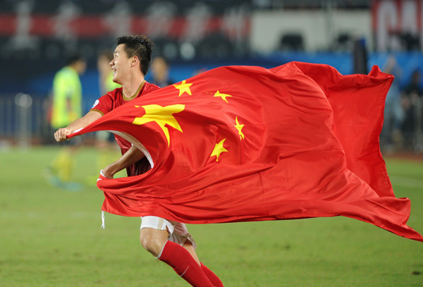 A football player from China's top club Guangzhou Evergrande celebrates victory after a match. [File photo]