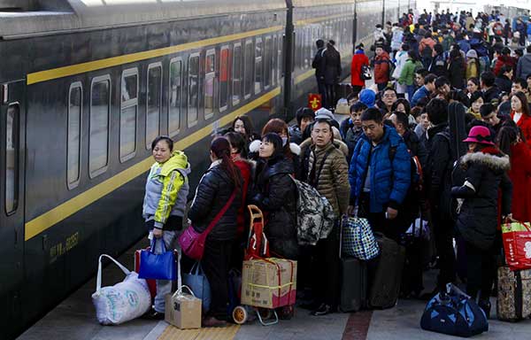 Passengers wait in line to catch trains home at the Beijing West Railway Station on Tuesday. (Photo/China Daily)