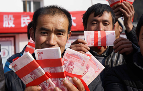 Low income families receive cash bonuses from their chicken farm cooperative on Jan 29. (Photo/xinhuanet.com)