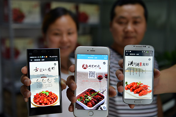 A couple running a catering startup in Huai'an, Jiangsu province, show the app through which they sell their products. (Photo/Xinhua)