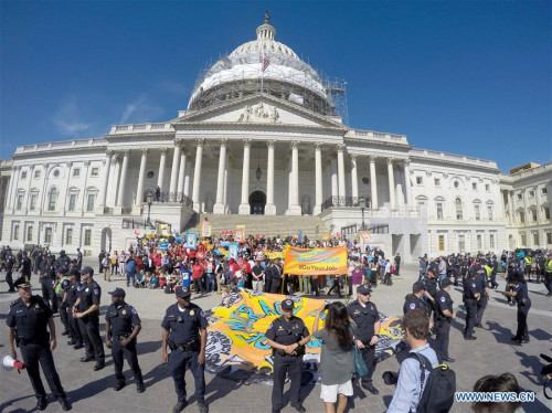 U.S. Capitol Police surround protestors who volunteer to be arrested during a demonstration against Money Politics on Capitol Hill in Washington D.C., the United States, on April 18, 2016. Few hundreds of protestors were arrested, according to demonstration organizers.(Photo: Xinhua/Yin Bogu)